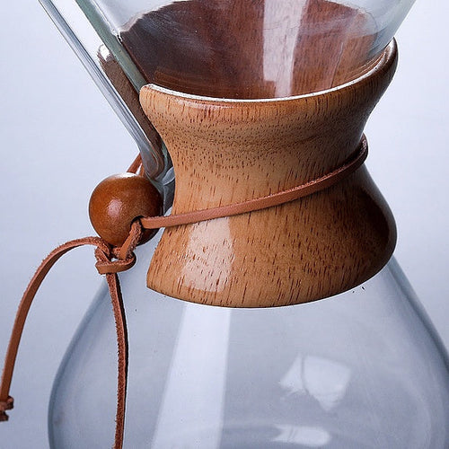 Cafetière pour-over remplie de café filtre, grains de café en arrière-plan