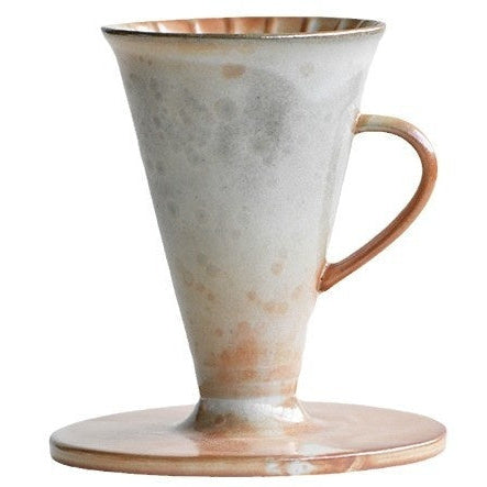 Détail du dripper céramique : rainures spirales et orifice d'écoulement